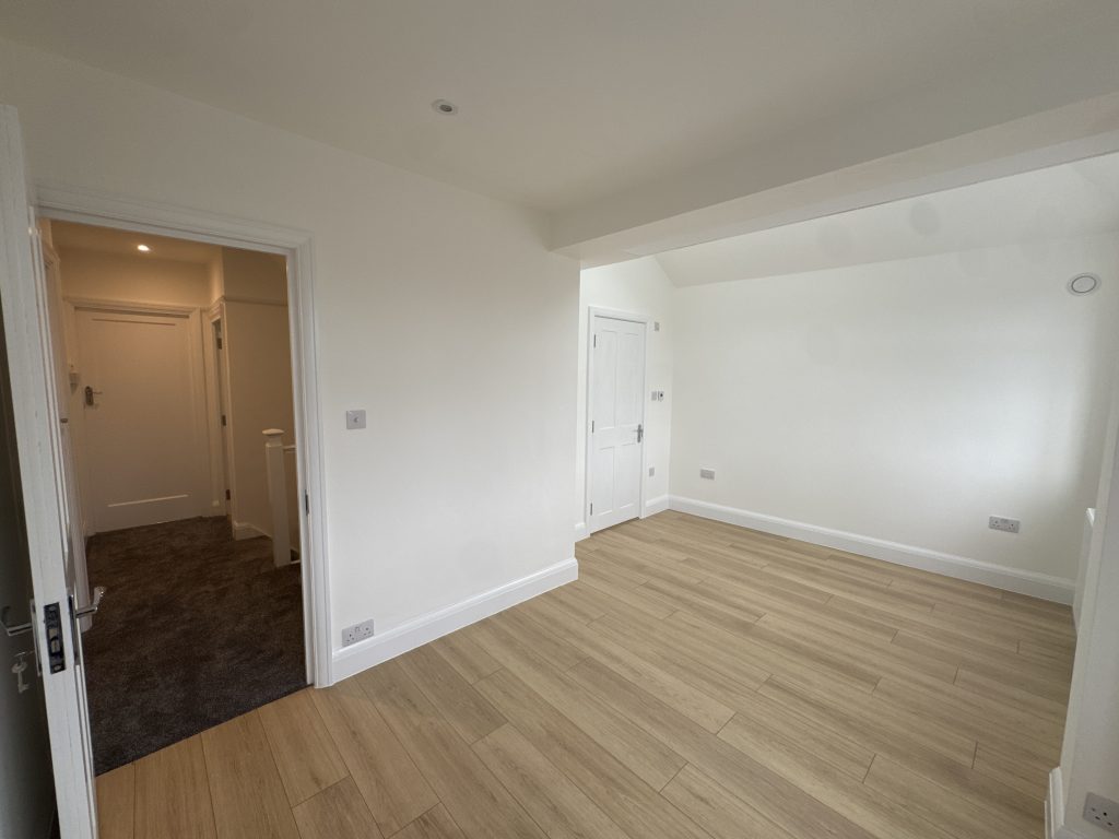 Bright finished interior room with light oak flooring, white walls and recessed lighting in a Kingston upon Thames extension and loft conversion by Albdeco